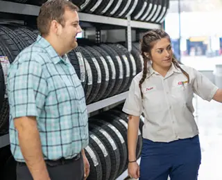 Les Schwab employee showing a customer different tire brands