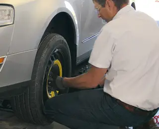 A Les Schwab technician removing a spare tire