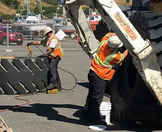 Les Schwab employees changing a giant tire.