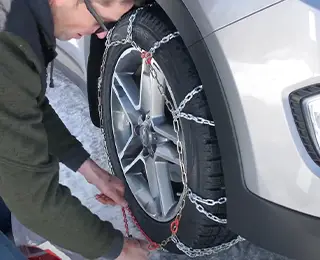 Man installing tire chains on a tire