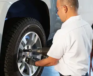 A Les Schwab technician installing winter tires