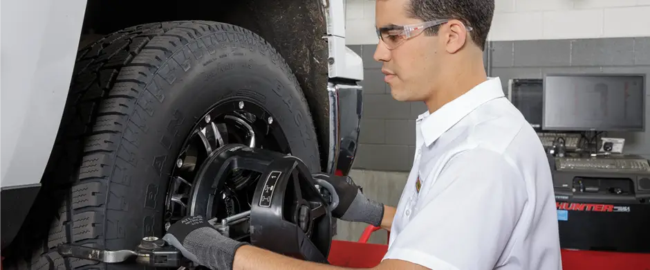 Les Schwab employee adjusting alignment on a pickup