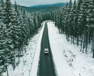 Car driving down a snowy road