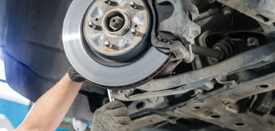 Technician adjusting disc brake on car