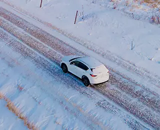 Car driving down a snowy road