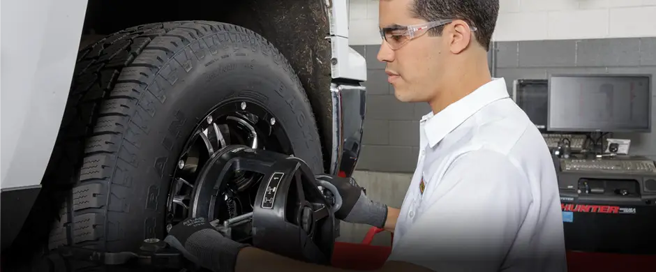 Les Schwab employee adjusting alignment on a pickup