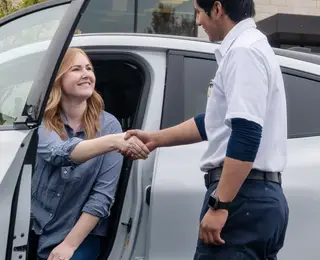 Les Schwab Technician greets a customer at her car