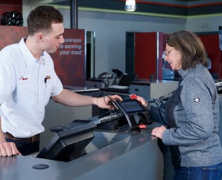 A Les Schwab employee helping a customer with their credit card