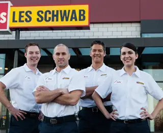 Four Les Schwab technicans pose in front of store.