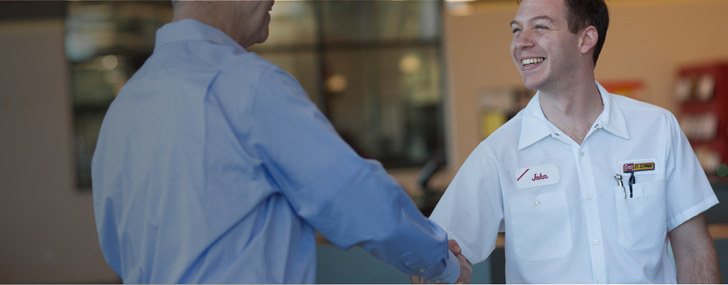 A Les Schwab technician shakes hands with a customer.